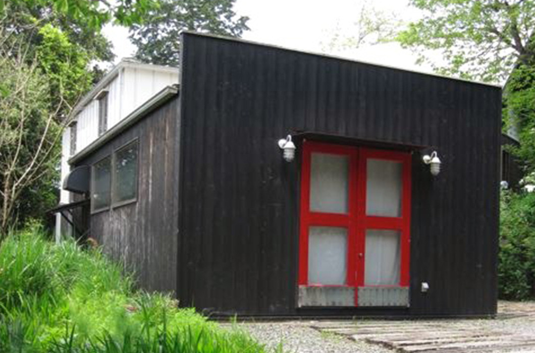 黒い板壁と赤い扉の建物がギャラリー棟